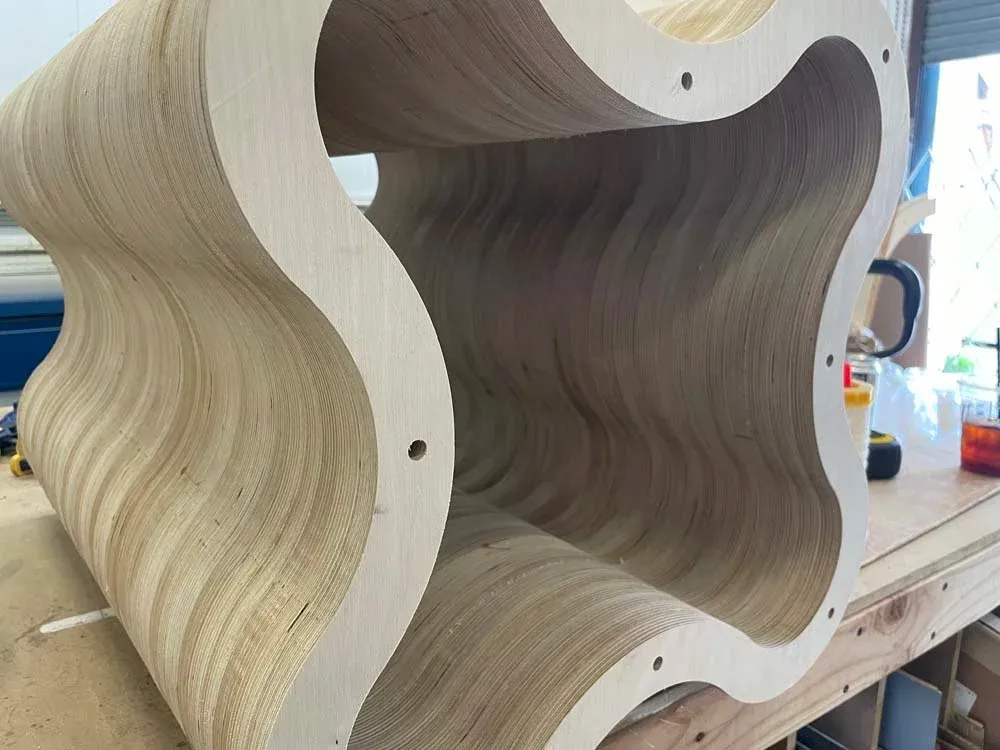 Stack-laminated Baltic birch profiles forming undulating table legs for an Alice + Olivia retail table