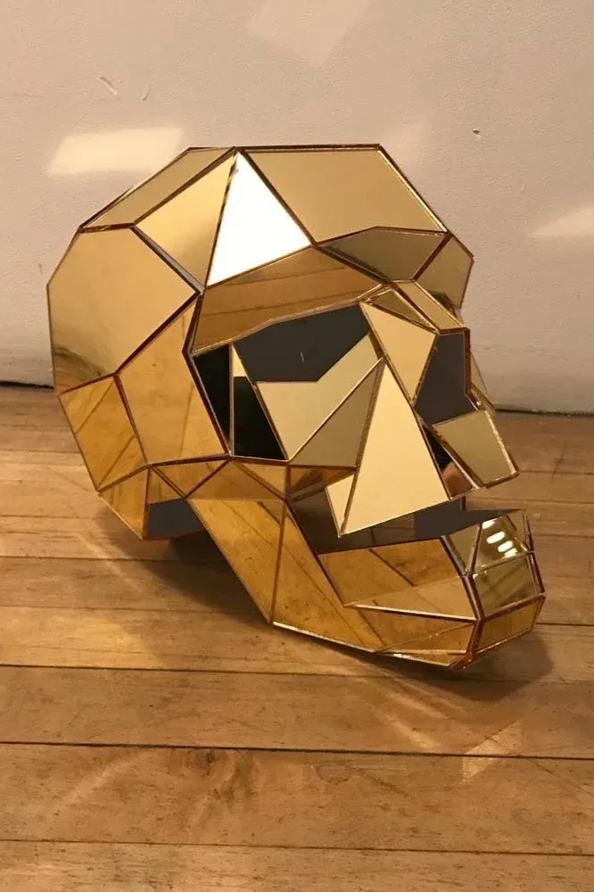 Geometric skull sculpture in gold mirror acrylic, laser-cut and assembled from angular facets