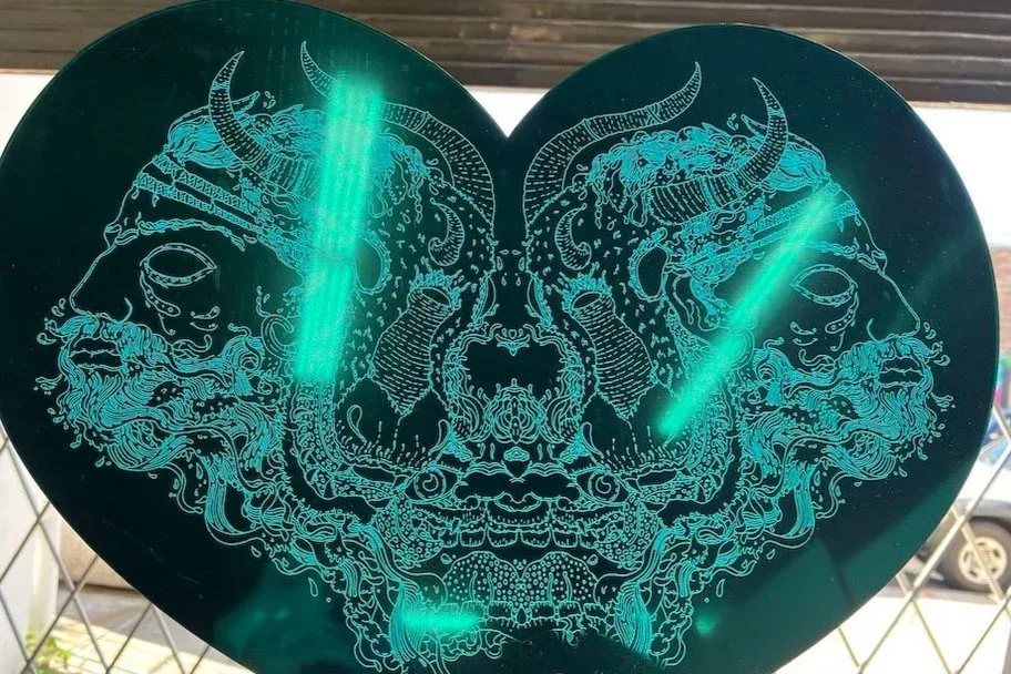 Teal mirror acrylic heart laser-etched with symmetrical line art for back-illumination